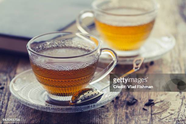 cup of green tea on a vintage rustic wood blurry or bokeh background - green tea leaves stockfoto's en -beelden