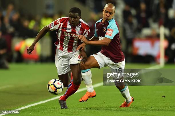 Stoke City's French defender Kurt Zouma vies with West Ham United's Portuguese midfielder Joao Mario during the English Premier League football match...