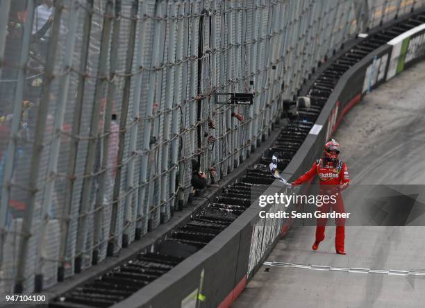 Kyle Busch, driver of the Skittles Toyota, celebrates with the checkered flag after winning the rain delayed Monster Energy NASCAR Cup Series Food...