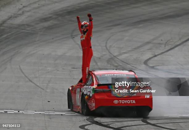 Kyle Busch, driver of the Skittles Toyota, celebrates with the checkered flag after winning the rain delayed Monster Energy NASCAR Cup Series Food...