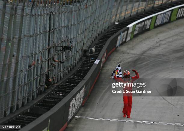 Kyle Busch, driver of the Skittles Toyota, celebrates with the checkered flag after winning the rain delayed Monster Energy NASCAR Cup Series Food...