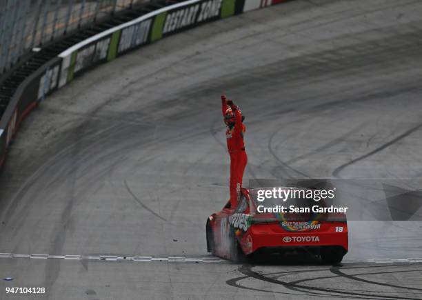 Kyle Busch, driver of the Skittles Toyota, celebrates with the checkered flag after winning the rain delayed Monster Energy NASCAR Cup Series Food...