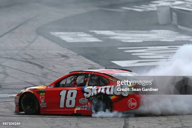 Kyle Busch, driver of the Skittles Toyota, celebrates with a burnout after winning the rain delayed Monster Energy NASCAR Cup Series Food City 500 at...