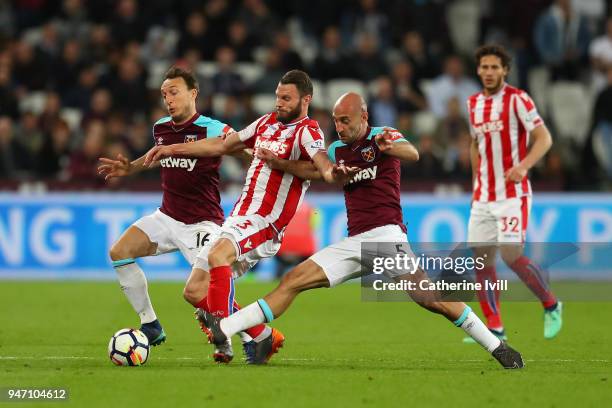 Erik Pieters of Stoke City, Mark Noble of West Ham United and Pablo Zabaleta of West Ham United battle for possession during the Premier League match...