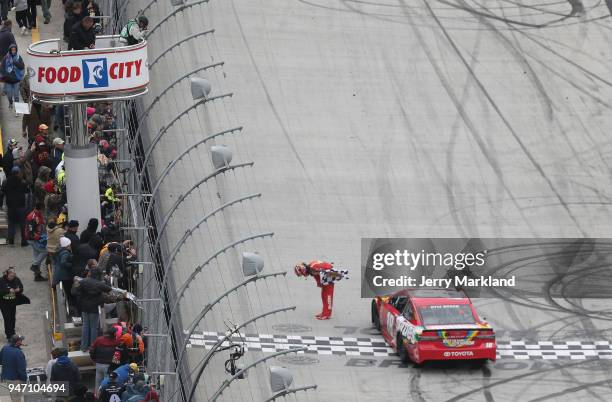 Kyle Busch, driver of the Skittles Toyota, celebrates with the checkered flag after winning the rain delayed Monster Energy NASCAR Cup Series Food...