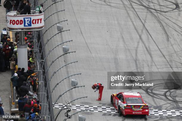 Kyle Busch, driver of the Skittles Toyota, celebrates with the checkered flag after winning the rain delayed Monster Energy NASCAR Cup Series Food...