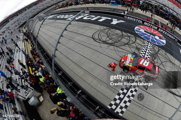 Kyle Busch, driver of the Skittles Toyota, celebrates with the checkered flag after winning the rain delayed Monster Energy NASCAR Cup Series Food...