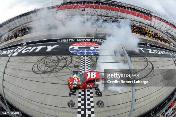 Kyle Busch, driver of the Skittles Toyota, celebrates with a burnout after winning the rain delayed Monster Energy NASCAR Cup Series Food City 500 at...