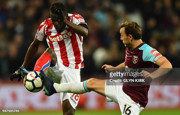 West Ham United's English midfielder Mark Noble vies with Stoke City's Senegalese striker Mame Biram Diouf during the English Premier League football...