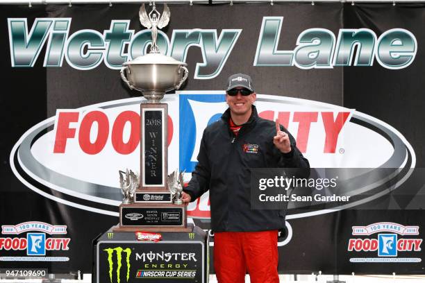 Kyle Busch, driver of the Skittles Toyota, poses with the trophy after winning the rain delayed Monster Energy NASCAR Cup Series Food City 500 at...