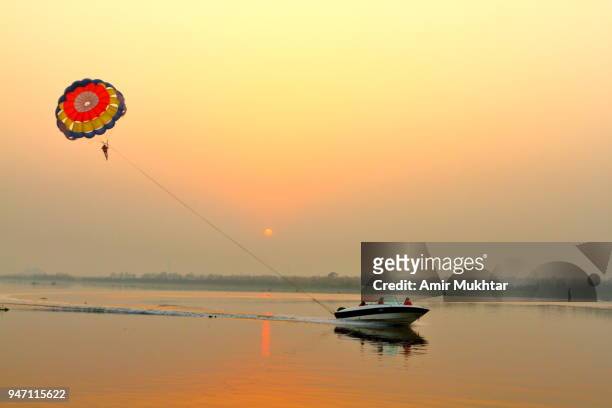 parasailing in the river at sunset - パラシュート ストックフォトと画像