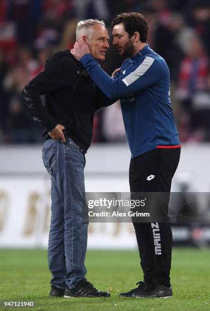 Christian Streich, head coach of Freiburg is consoled by Sandro Schwarz; head coach of Mainz after the Bundesliga match between 1. FSV Mainz 05 and...