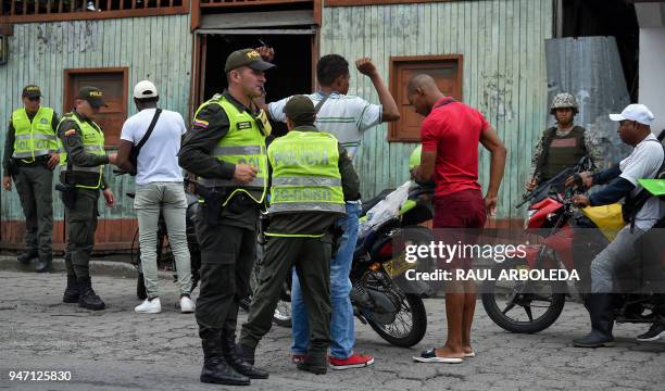 Police officer frisks a man in Tumaco, a municipality in the Colombian department of Narino near the border with Ecuador, on April 16, 2018 days...