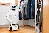cyborg or autonomous robot is putting clothes into or out of the wardrobe, showing personal fashion preferences