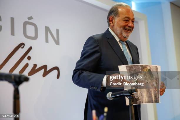 Carlos Slim, chairman emeritus of America Movil SAB, holds up an image of the New International Airport of Mexico City during a press conference in...