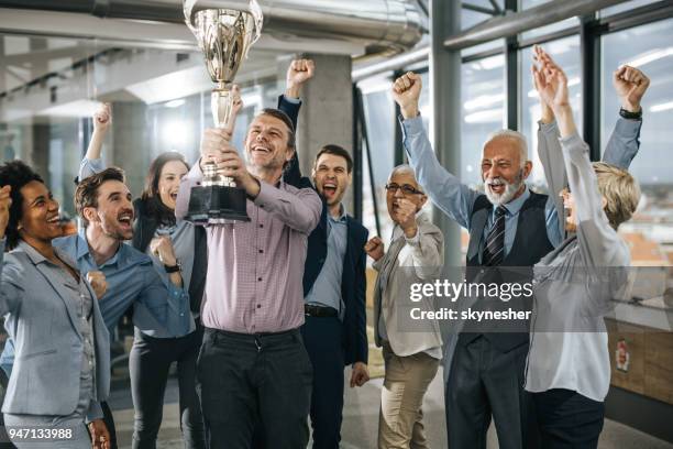 large group of cheerful business people celebrating success with a trophy in the office. - cup office stock pictures, royalty-free photos & images