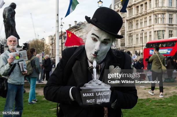 Charlie Chaplin look-alike joined hundreds of anti-war demonstrators in Parliament Square in central London to protest against military interventions...