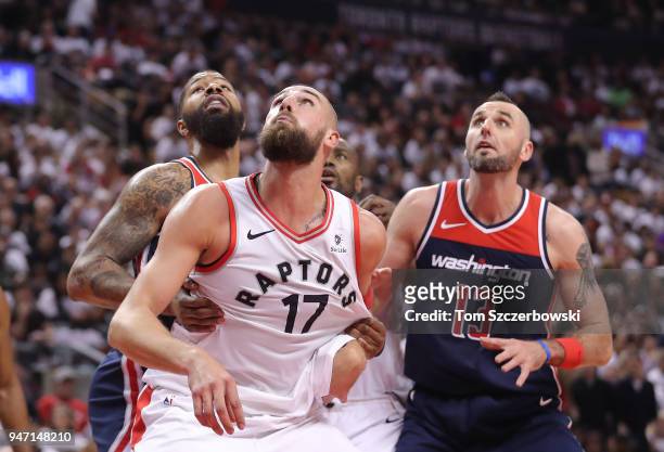 Jonas Valanciunas of the Toronto Raptors and Marcin Gortat of the Washington Wizards anticipate a rebound as Markieff Morris and Serge Ibaka look on...