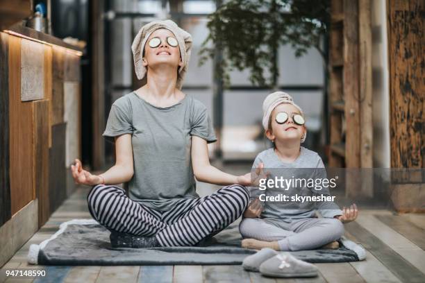 relaxed mother and daughter exercising yoga in the morning at home. - weekend activities stock pictures, royalty-free photos & images