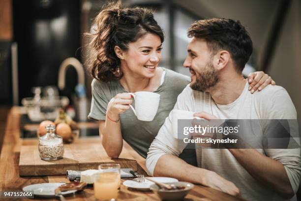 omfamnade par i kärlek kommunicerar under kaffe tid i köket. - couple breakfast bildbanksfoton och bilder