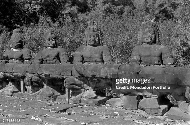 The giants supporting a long snake at the entrance of the city of Angkor Thom. Angkor Thom, 1960s