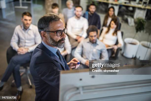 mogen affärsman gör en plan för hans kollegor på en utbildning klass. - corporate training bildbanksfoton och bilder