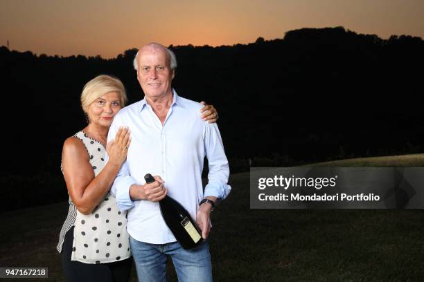 Entrepreneur Giancarlo Aneri with a bottle of Aneri spumante, being hugged by his wife Valeria. Conegliano, Italy. 14th September 2016