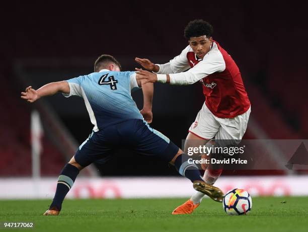 Xavier Amaechi of Arsenal takes on Jack Newton of Blackpool during the match between Arsenal and Blackpool at Emirates Stadium on April 16, 2018 in...