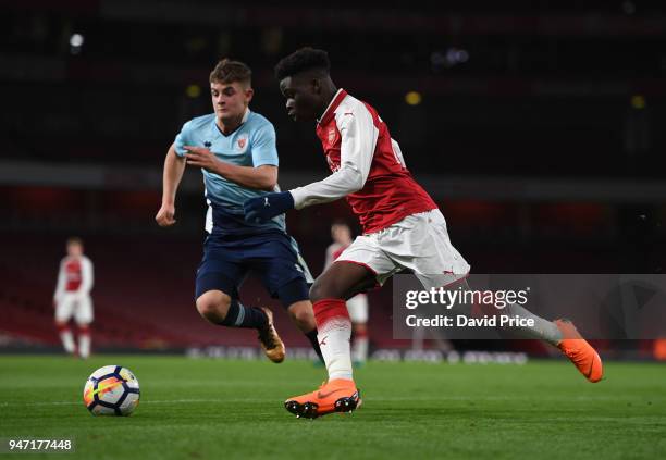 Bukayo Saka of Arsenal takes on Jack Newton of Blackpool during the match between Arsenal and Blackpool at Emirates Stadium on April 16, 2018 in...