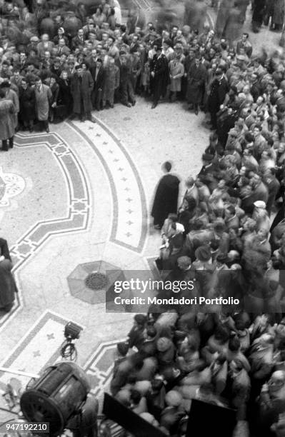 Bystanders crowd around the set during the shooting of the movie Nata di marzo inside Galleria Vittorio Emanuele II. Milan , November 3rd 1957.