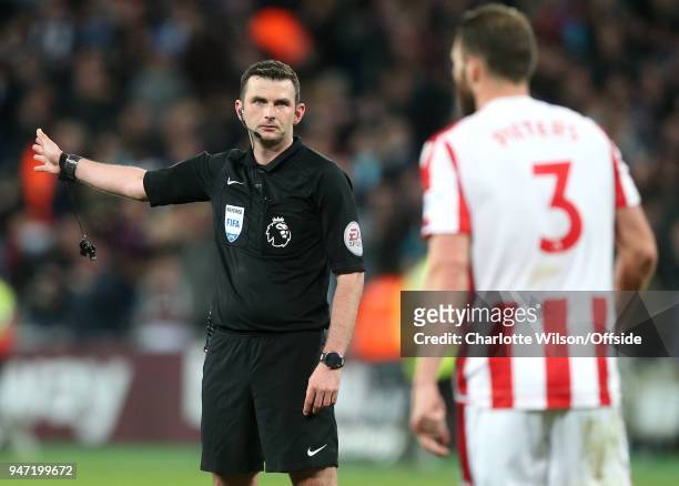 Referee Michael Oliver moves players back up the pitch during the Premier League match between West Ham United and Stoke City at London Stadium on...