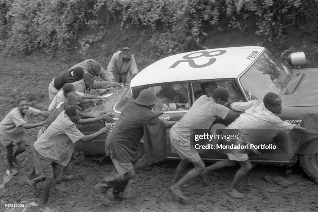 A car taking part in the East African Safari Rally bogged down in the mud