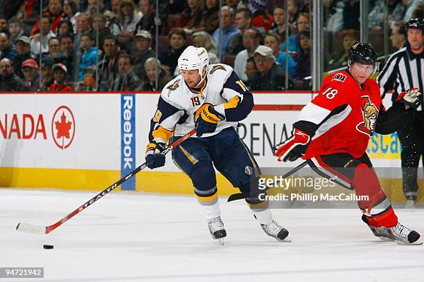 Tim Connolly of the Buffalo Sabres cuts inside with the puck away from Jesse Winchester of the Ottawa Senators during a game at Scotiabank Place on...