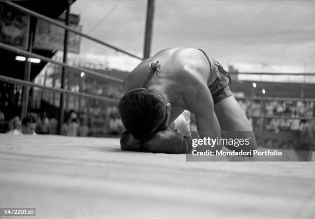 Muay Thai fighter kneeling on the ring. Bangkok, 1961