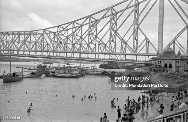 People bathing in the Hooghly river next to the Howrah Bridge. Kolkata, 1962