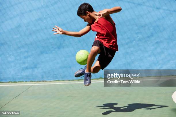 boy playing football - zuid amerika stockfoto's en -beelden