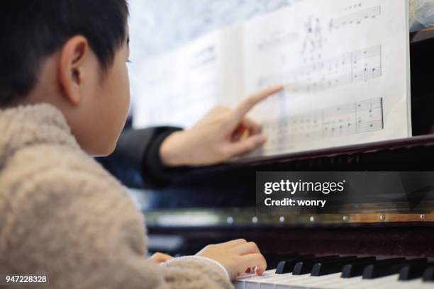 young boy learning to play piano - practicing piano stock pictures, royalty-free photos & images