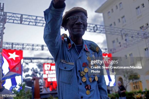 Former Cuban militia fighter raises his arm at the end of a political act commemorating the 57th anniversary of a speech in which leader Fidel Castro...