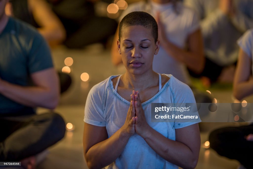 Woman Meditating In A Dim Room
