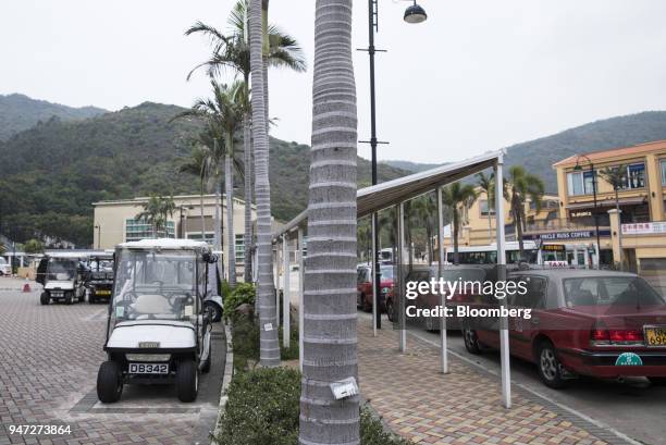 Golf carts stand parked next to a taxi stand in Discovery Bay, a residential project developed by Hong Kong Resort Co., on Lantau Island in Hong...