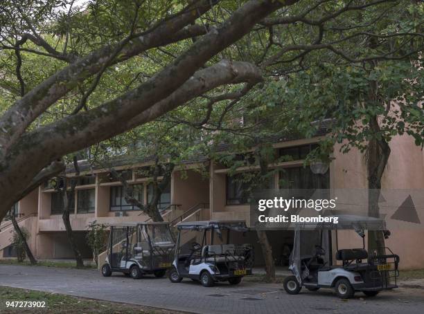 Golf carts stand parked in front of a low-rise building in Discovery Bay, a residential project developed by Hong Kong Resort Co., on Lantau Island...