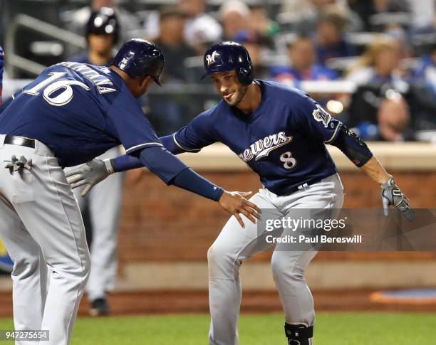 Domingo Santana greets teammate Ryan Braun of the Milwaukee Brewers at the plate as they celebrate a home run by Braun in an MLB baseball game...