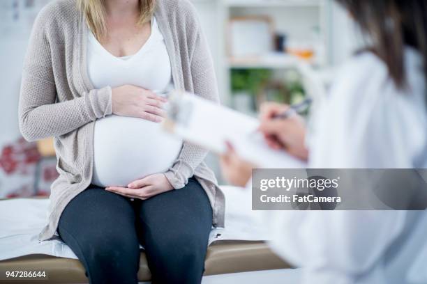 schwangerschaft untersuchen lassen - pregnant woman at doctor stock-fotos und bilder