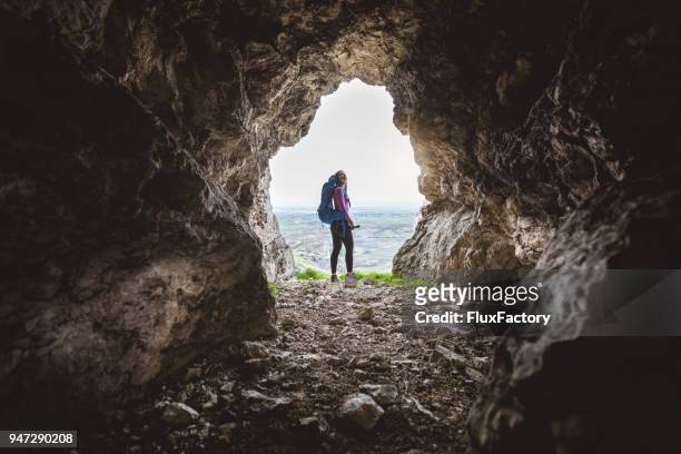 randonneur explorant la grotte - irréductibilité photos et images de collection