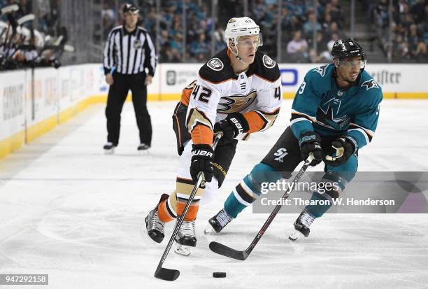 Josh Manson of the Anaheim Ducks skates up ice with control of the puck pursued by Evander Kane of the San Jose Sharks during the third period in...