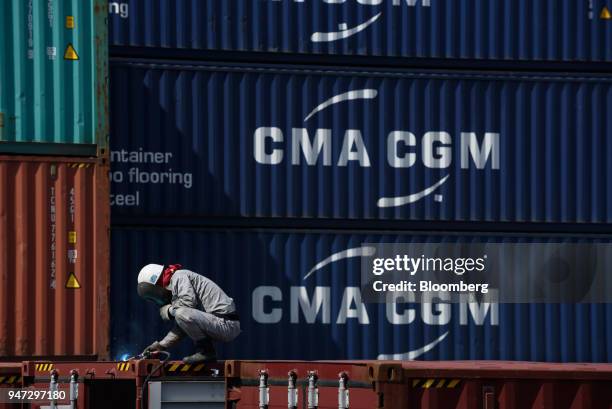 Man performs maintenance work on a container at a shipping terminal in Yokohama, Japan, on Monday, April 16, 2018. Japan and China held their first...