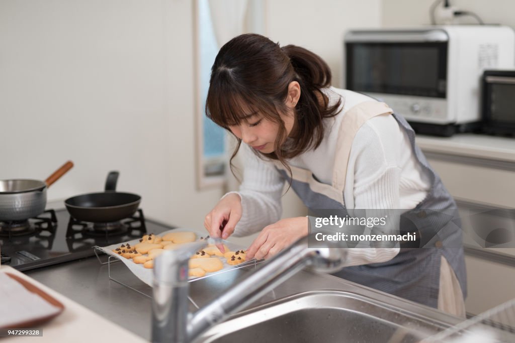 Woman putting cookie on paper