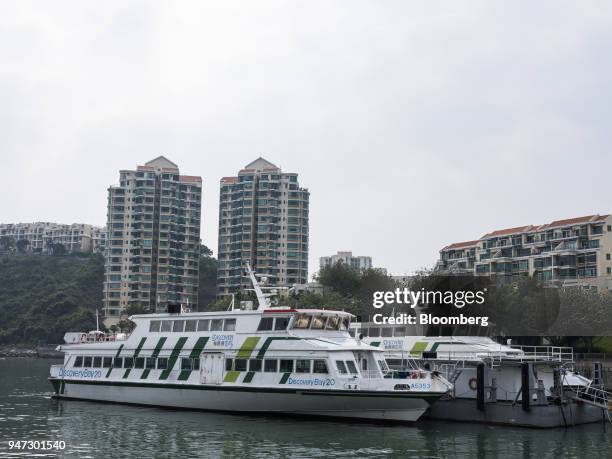 Ferries are moored in front of apartment buildings in Discovery Bay, a residential project developed by Hong Kong Resort Co., on Lantau Island in...