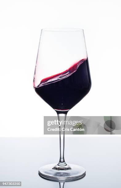 red wine swirling into glass - red wine glass stock pictures, royalty-free photos & images