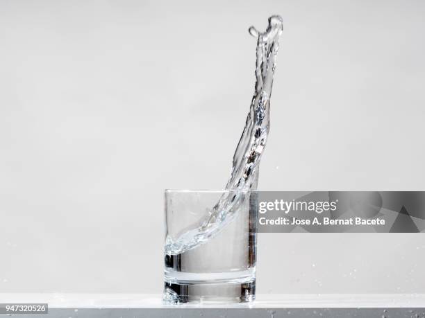 impact of a glass of crystal with water that falls down on the table. - half full stock pictures, royalty-free photos & images